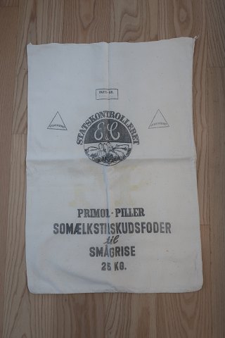 Gammel sæk
Tekst: "Statskontrolleret Vitaminiseret - Primol - Piller - 
Somælkstilskudsfoder til smågrise - 25 kg"
168cm x 46cm
God stand
Vi har et godt udvalg af gamle sække både med og uden tekst