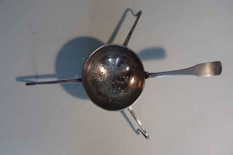 Antik tesi af sølv med initialer
Fra 1800-tallet
Ikke stemplet
L: ca. 16cm med håndtag, selv tesien er ca. 5cm i diameter